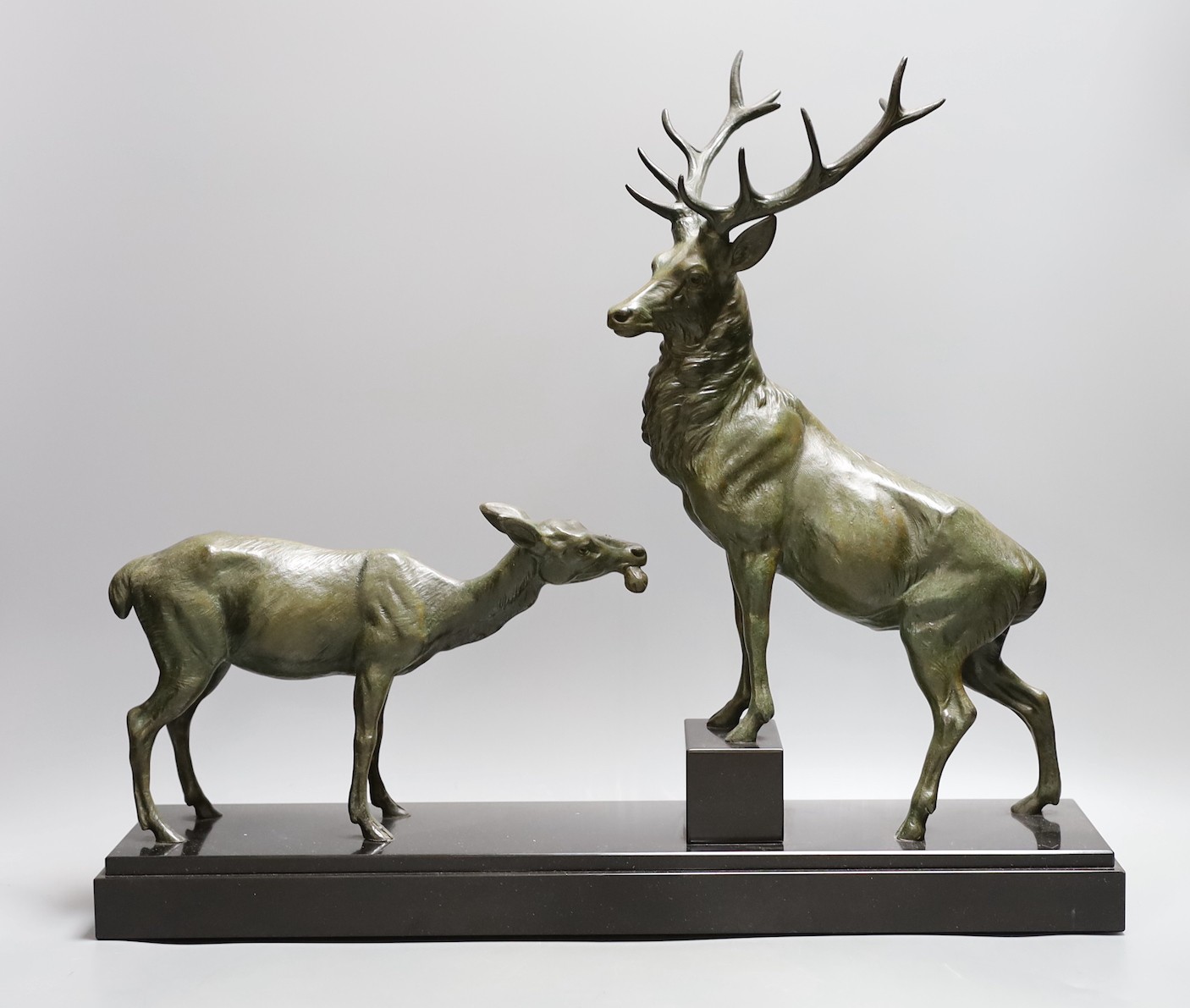 A French bronzed metal model of a stag and deer on a black marble base, signed L. Carvin, 43 cms high